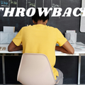 A boy at his desk doing work wearing a yellow shirt