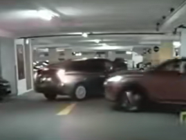 A car shoots up a ramp and slams into a walk inside an underground parking lot