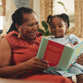 A grandmother reads a book with her granddaughter