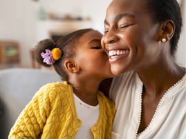 A little girl kissing her mother on the cheek