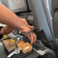 A man gets hand stuck inside a cup holder during his flight
