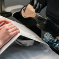 A nail technician works on a customer's nails