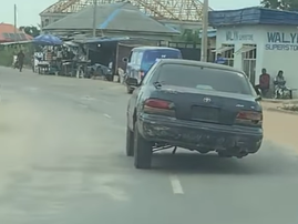 A vehicle driving on a road without a fourth tyre