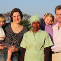 A white South African family standing with their domestic helper