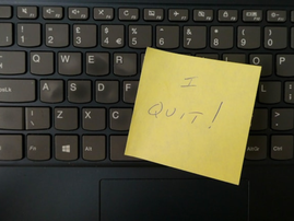 A yellow notepad on a keyboard that reads I Quit