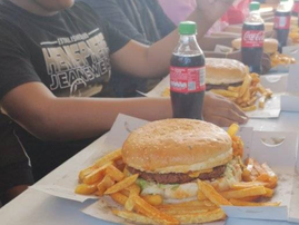 People seated at a table for a Monster Burger eating challenge in Phoenix Durban