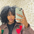 SZA takes a selfie while holding a thumb's up sign